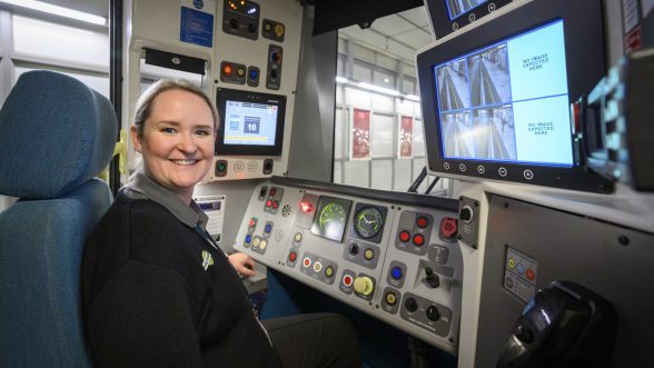 Woman train driver in the train driver seat smiling